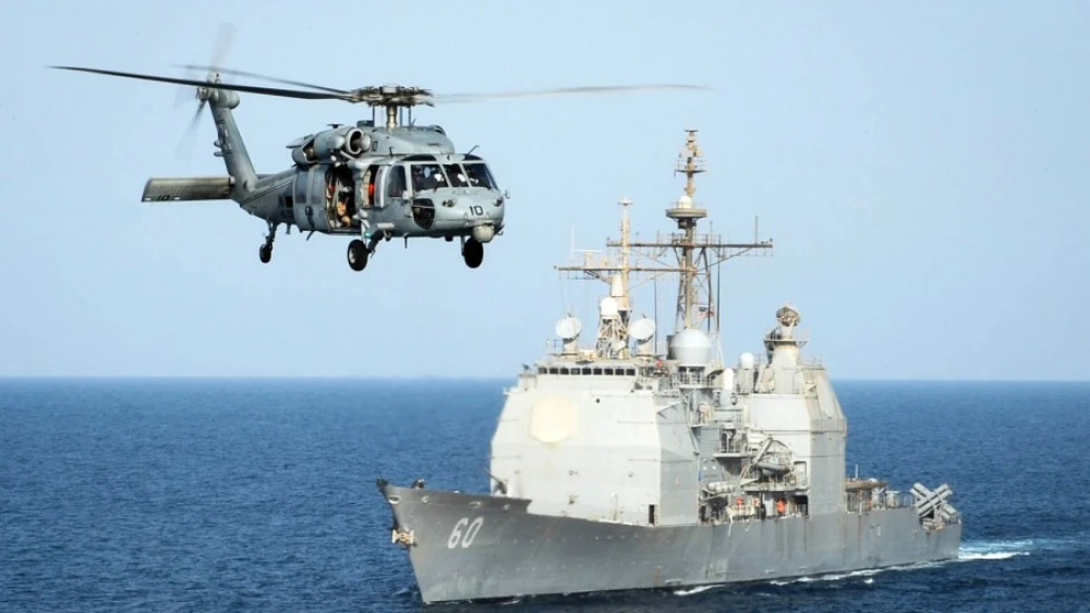 An HH-60H Sea Hawk helicopter passes the guided-missile cruiser “USS Normandy” in the Arabian Gulf in September 2015. Credit: Anna Van Nuys/U.S. Navy.