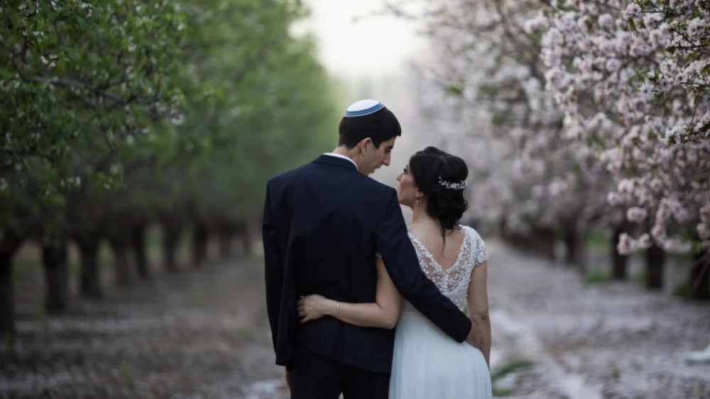 An Israeli couple on their wedding day photoshoot in a blossoming almond tree field in Latrun, near Jerusalem, on Feb. 25, 2019. Photo by Hadas Parush/Flash90.