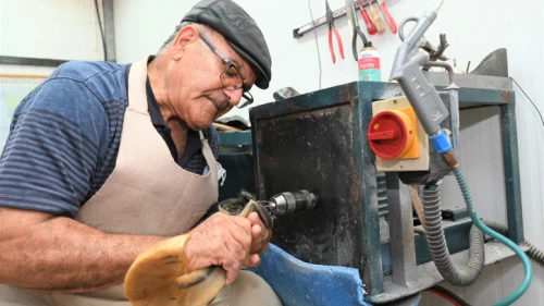 Shofar specialist Shimon Keinan at work at the Kol Shofar workshop in Givat Yoav in the southern Golan Heights, August 23, 2021. Photo by Michael Giladi/Flash90.