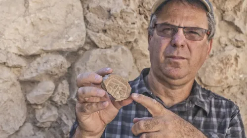 Professor Yuval Gadot from Tel Aviv University with the seal. Credit: Shai Halevy, Israel Antiquities Authority.