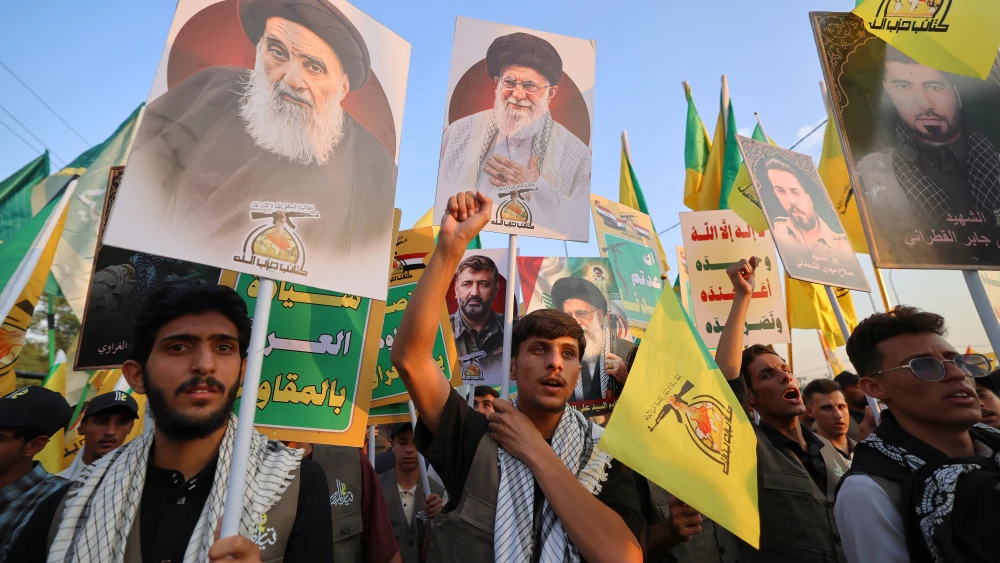 Supporters of Iran-aligned armed factions march with portraits of Iran's slain supreme leader Ali Khamenei and Iraq's supreme Shia Muslim cleric Ayatollah Ali Sistani during a rally celebrating the withdrawal of forces of the US-led coalition against the Islamic State from Iraq, in Baghdad on September 30, 2026. Photo by Ahmad Al-Rubaye/AFP via Getty Images.