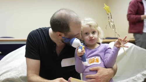 A parent and child huddle together during a Home Within the Heart session. Home Within the Heart is a University of Haifa initiative — run by Dr. Yael Enav and Dr. Yael Mayer — that focuses on the parent-child relationship as the most powerful source of healing. Credit: Home Within the Heart archive.