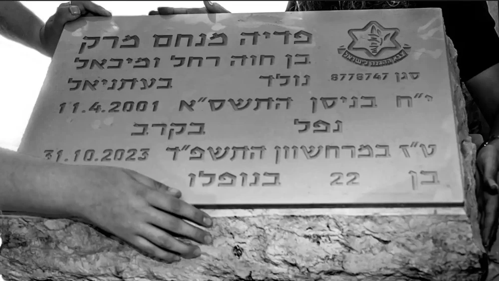 The hands of Tehila Mark and her sister, Orit Mark-Ettinger, rest on the grave of their brother, IDF Lt. Pedayah Mark, in Jerusalem, Sept. 24, 2026. Photo by Rina Castelnuovo.
