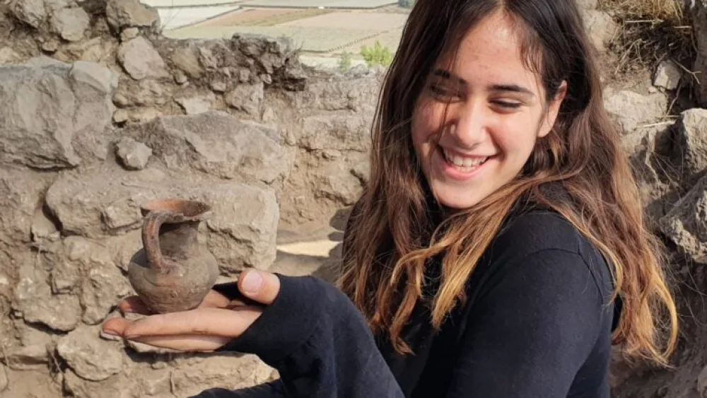 Student Tamar Cohen holding a Hellenic jug discovered in Lachish Forest. Photo by Saar Ganor/Israel Antiquities Authority.