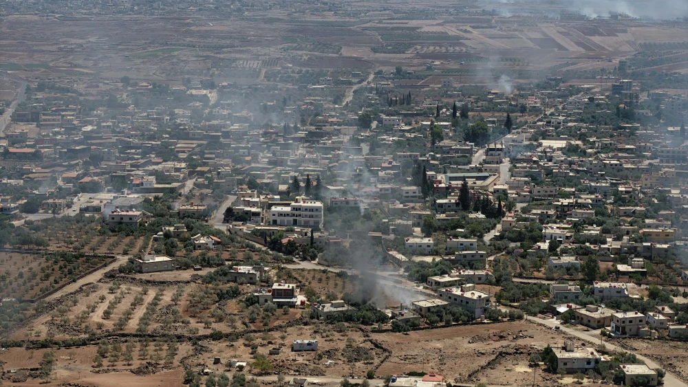 This aerial photograph shows smoke rising above buildings in al-Mazraa village in Syria's southern Sweida governorate as clashes between fighters from Bedouin tribes and Druze gunmen continues on July 07, 2025 in Sweida, Syria. Photo by Ali Haj Suleiman/Getty Images.