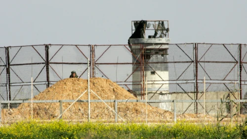 An Israeli soldier watches Palestinian protesters during clashes near the Israel-Gaza border east of Khan Younis in the southern Gaza Strip, March 2, 2018. Photo by Abed Rahim Khatib/Flash90.