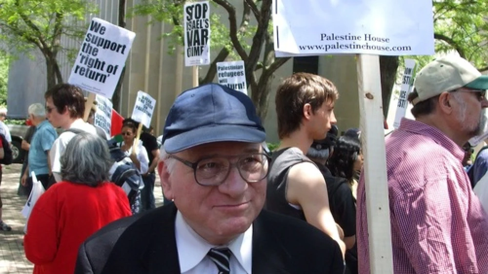 Danny Goldstick holding a "Freedom For Palestine!" sign at a demonstration accusing Israel of apartheid. The New Israel Fund has cut off funding to several groups that demonize Israel, but has continued to fund others, according to JNS columnist Gerald Steinberg. Credit: Johan1917/Wikimedia Commons.