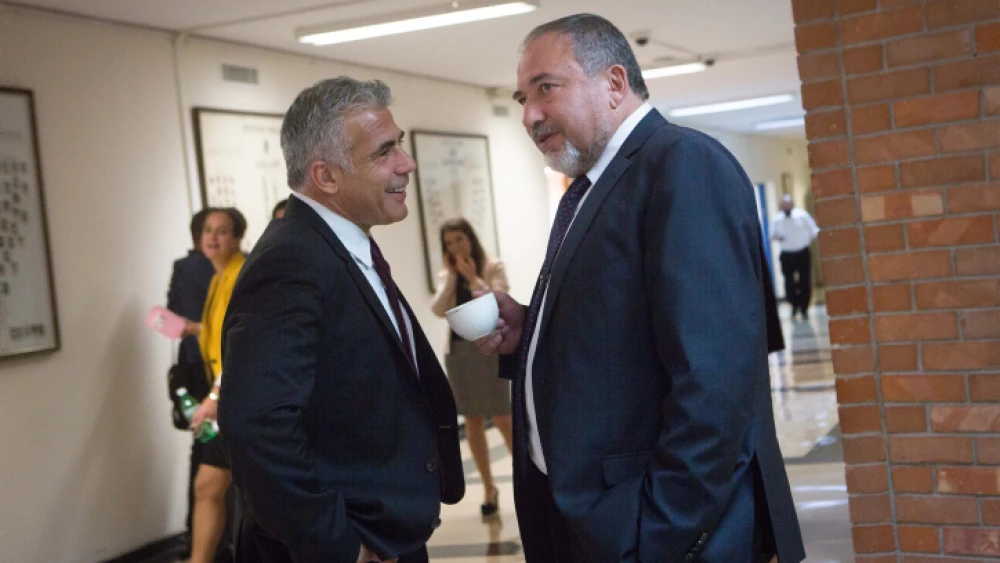 Yisrael Beiteinu leader Avigdor Lieberman (right) speaks with Yesh Atid Party leader Yair Lapid in the corridors of the Knesset on Nov. 16, 2015. Photo by Miriam Alsterl/Flash90.