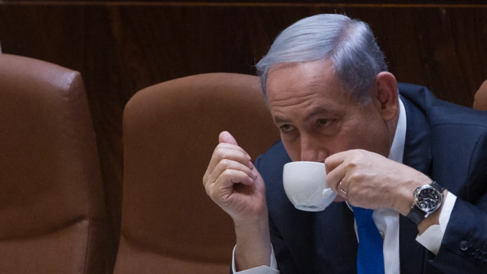 Israeli Prime Minister Benjamin Netanyahu seen drinking coffee during a plenum session in the assembly hall of the Israeli parliament on June 17, 2015. Photo by Miriam Alster/Flash90.