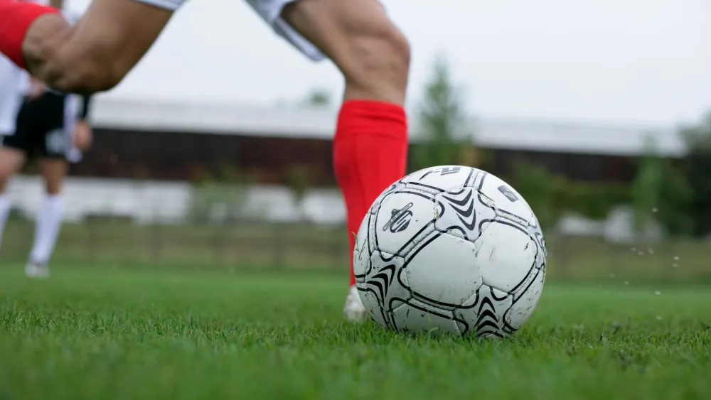 People playing soccer on a field. Credit: BOOM Photography/Pexels.