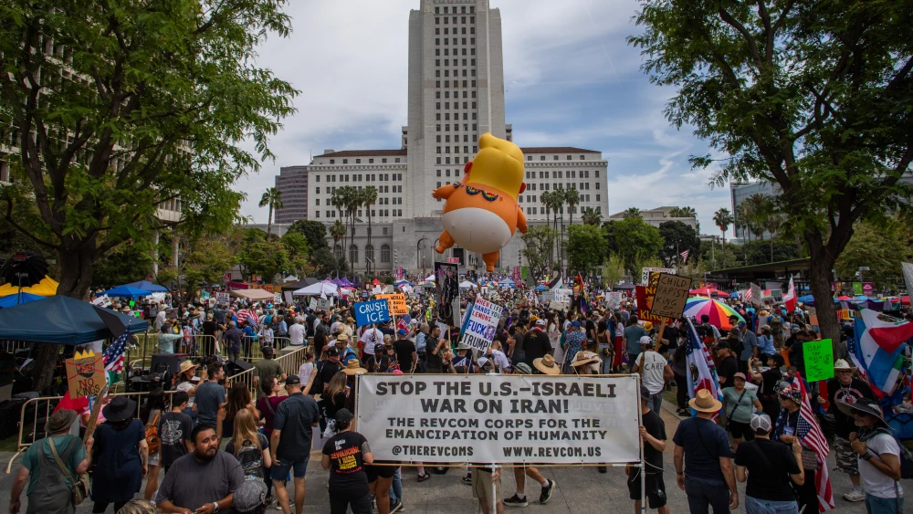 Crowds hold signs in front of City Hall in Los Angeles to protest immigration enforcement and federal overreach during a national "No Kings" protest, the third such major rally against the second term of U.S. President Donald Trump. Photo by Apu Gomes/Getty Images.