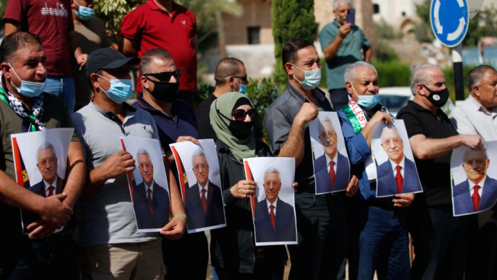 Palestinians hold photo printouts during a rally in support of Palestinian Authority leader Mahmoud Abbas in the West Bank town of Tubas on Sept. 27, 2020. Photo by Nasser Ishtayeh/Flash90.