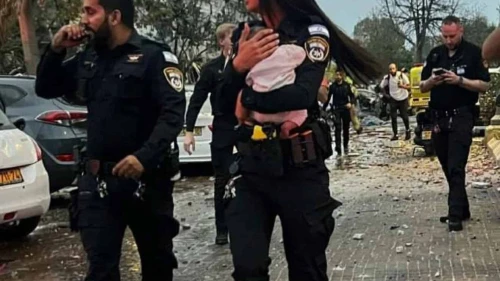 Police officer Staff Sgt. Aviv Saranga holding a three-month-old baby after she was pulled out of rubble in Rishon Letzion created by an Iranian ballistic missile strike on June 14, 2025. Photo by Dvir Mor/Israel Police.