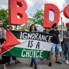Protesters in Berlin hold a Palestinian flag and the initials of the anti-Israel BDS movement while then-Israeli Prime Minister Benjamin Netanyahu was visiting Germany in August 2019. Credit: Israel Hayom.