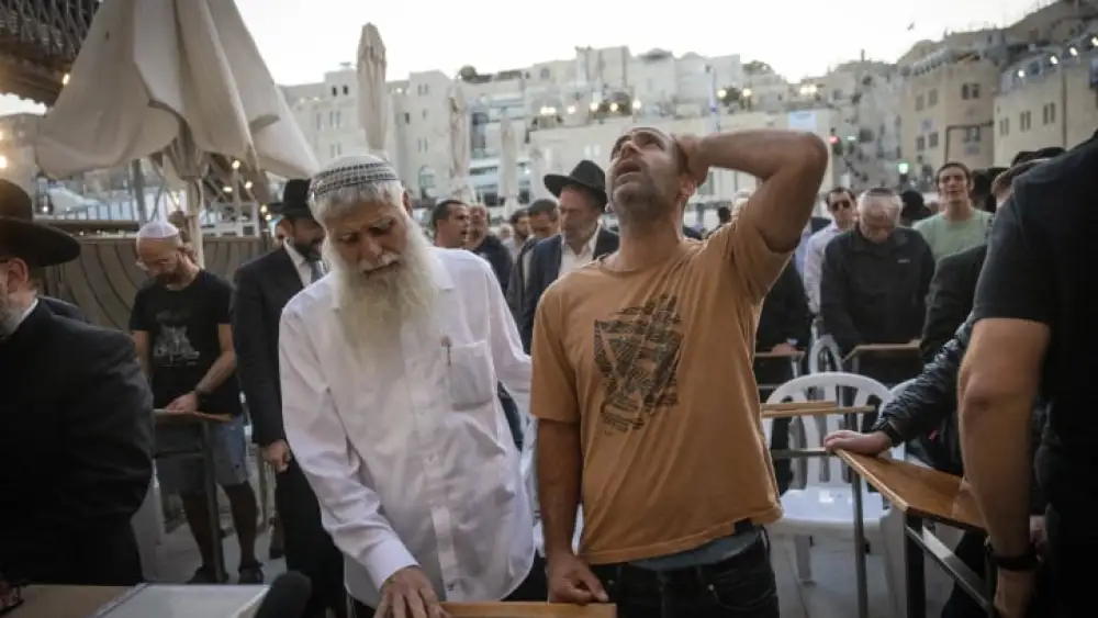 Avichai Brodtz, whose wife and three children were abducted by Hamas, and Shmuel Rabinowitz, the rabbi of the Western Wall, pray for the release of people held hostage, at the Western Wall in Jerusalem, October 19, 2023. Photo by Chaim Goldberg/Flash90.