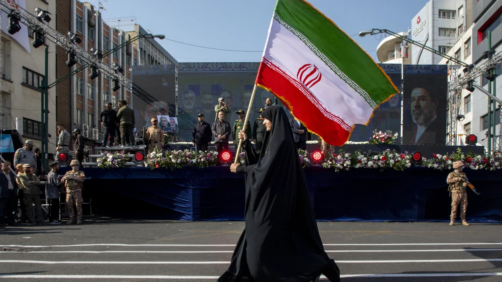 A woman carries an Iranian flag during the two-week ceasefire in place amid war with the United States and Israel as part of a pro-government National Army Day demonstration in Tehran on April 17, 2026. Photo by Majid Saeedi/Getty Images.