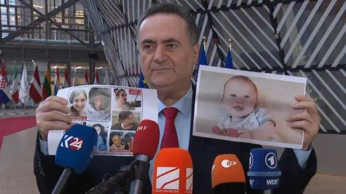 Israeli Foreign Minister Israel Katz holds up a photo of baby Kfir Bibas and a montage of several young women, all held hostage by Hamas in Gaza. Credit: MFA.