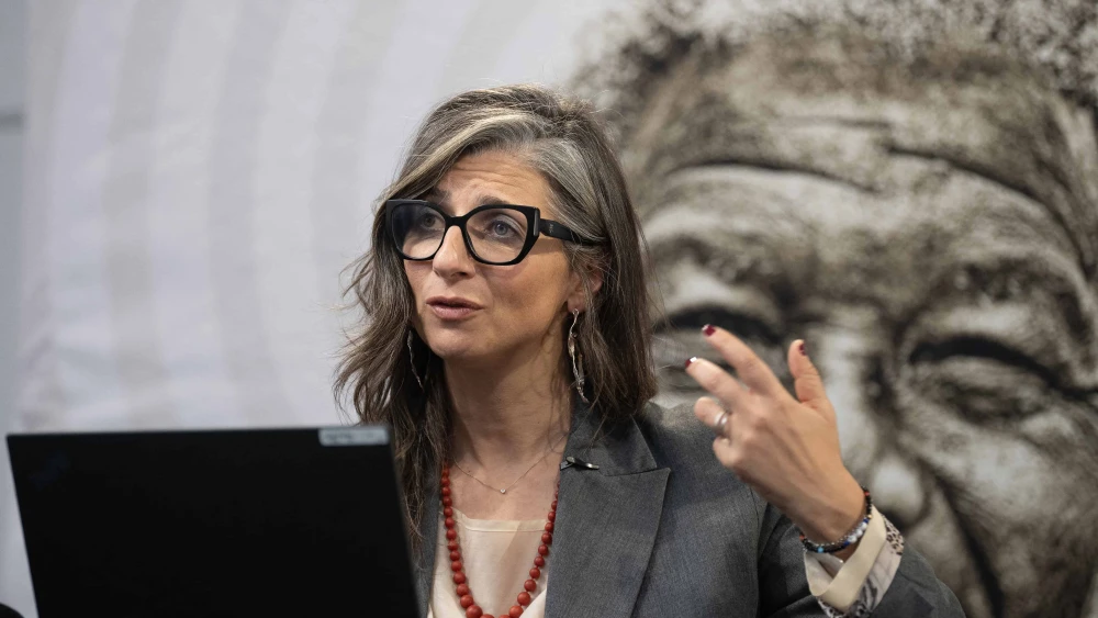 United Nations Special Rapporteur Francesca Albanese, sitting in front of an image of Nelson Mandela, addresses a press conference after her remote presentation of her latest report to the UN General Assembly, in Cape Town on Oct. 28, 2025. Photo by Rodger Bosch/AFP via Getty Images.