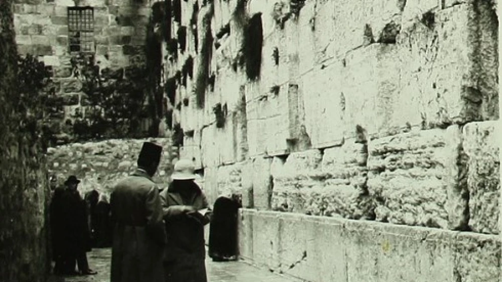 The Western Wall, circa 1920. According to "Life" magazine’s John Phillips, the window above the wall was in the Mufti’s house, where he “used to pass his days watching the Jews to see if they committed any crimes” such as bringing chairs or dividers. Credit: Israel National Library via Wikimedia Commons.