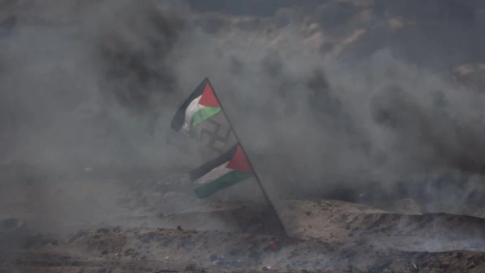 Palestinians display a flag with a swastika in the middle during Gaza border protests in April 2018. Credit: IDF via Twitter.