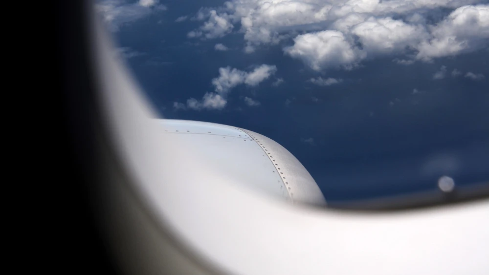 The clouds and sky outside an airplane window. Credit: annekroiss/Pixabay.