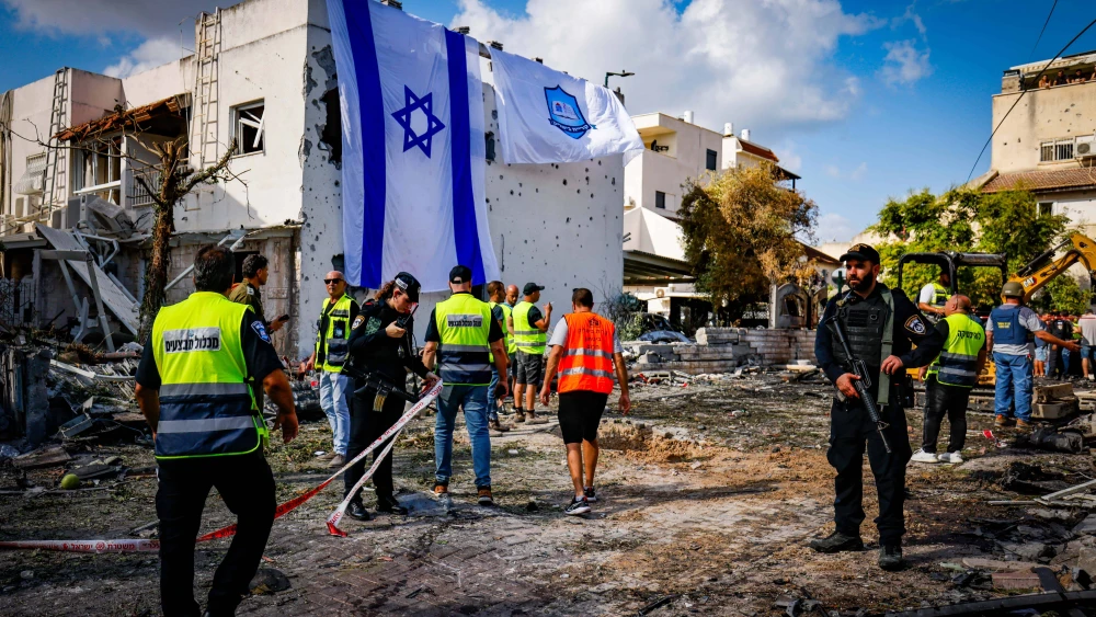 A giant Israeli flag covers the hole left by a rocket that terrorists from Lebanon fired at Kiryat Bialik, Israel, on Sept. 22, 2024. Photo by Chaim Goldberg/Flash90
