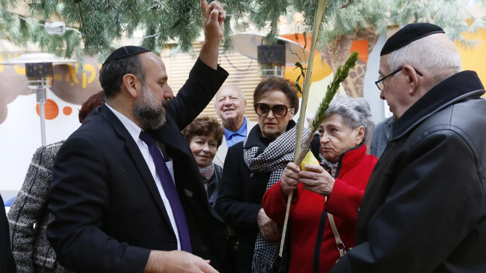 Chief Rabbi of Poland Michael Schudrich seen teaching “Children of the Holocaust” the blessing of the Four Species or Four Kinds, traditionally said during the Jewish holiday of Sukkot, in a sukkah built next to the Noszyk synagogue in Warsaw, Sept. 25, 2013. Photo by Miriam Alster/Flash90.