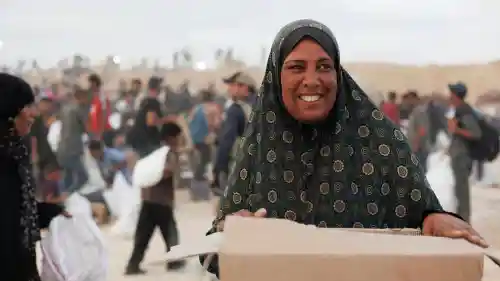 A Palestinian woman receives a food package from the Gaza Humanitarian Foundation in Gaza, June 2025. Credit: Gaza Humanitarian Foundation.