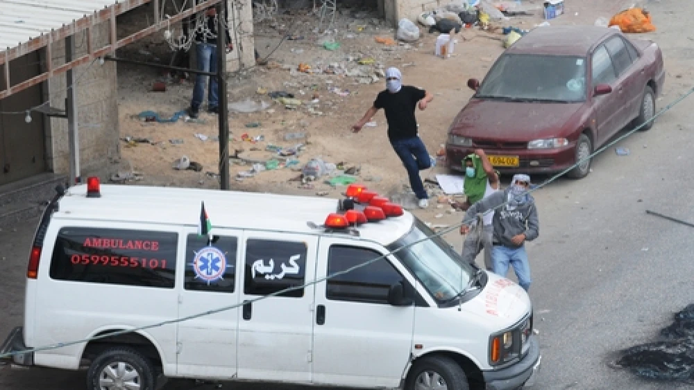 Click photo to download. Caption: Palestinian rioters in Qalandiya use an ambulance for cover as they hurl rocks in May 2011. Credit: Israel Defense Forces.
