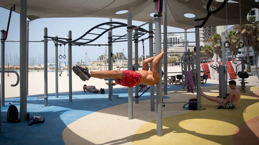 Israelis exercise at an outdoor gym at the beach in Tel Aviv on a hot summer day, July 28, 2020. Photo by Miriam Alster/Flash90.