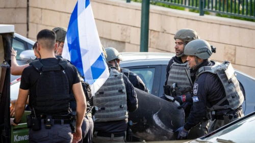 Police dispose of a rocket fragment that damaged a parking lot in Netivot in southern Israel, on May 13, 2023. Photo by Yonatan Sindel/Flash90.