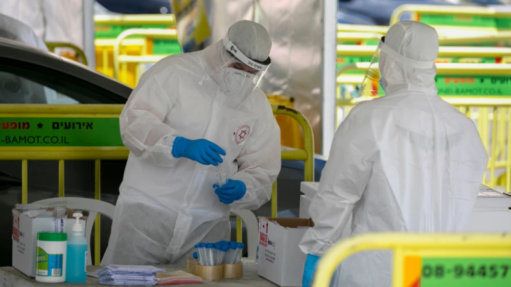 Magen David Adom medical workers at a drive-through COVID-19 testing site in Jerusalem on May 31, 2020. Photo by Olivier Fitoussi/Flash90.