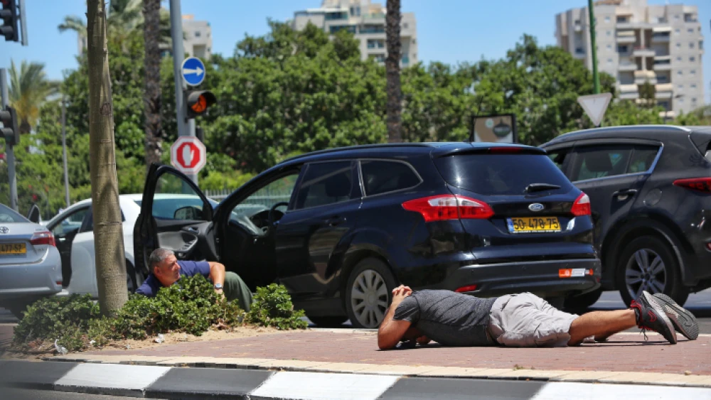 Israelis take cover in Ashkelon as a siren sounds a warning of rockets incoming from the Gaza Strip, on May 19, 2021. Photo by Edi Israel/Flash90.