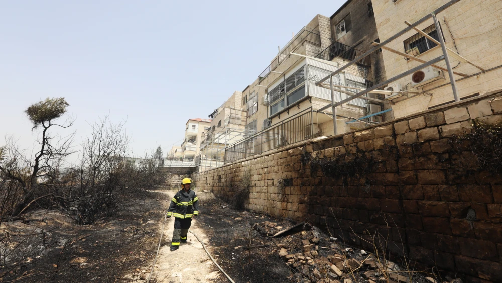 Firefighters try to extinguish a forest fire that broke out near a residential neighborhood in Ramat Beit Shemesh. The fire also spread to a nearby residential building, damaging two apartments, May 31, 2021. Photo by Yaakov Lederman/Flash90.
