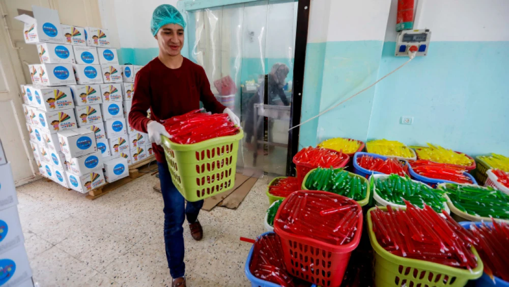 Palestinian workers sort ice pops at a factory in the West Bank village of Tafouh, near Hebron, on April 16, 2019. Photo by Wisam Hashlamoun/Flash90.
