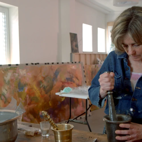 Beverly Barkat grinds material into fragments with a pestle and mortar for her artwork “After the Tribes,” to be exhibited in Rome. Credit: Photo by Tor Ben Mayor.