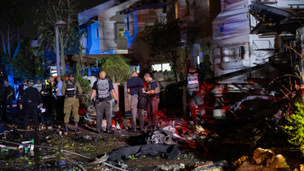 Police and rescue personnel at the scene of a building in Rishon Letzion which was directly hit by a rocket fired from the Gaza Strip, leaving one Israeli dead. More than 130 rockets were fired from Gaza into central Israel on May 11, 2021. Photo by Noam Revkin Fenton/Flash90.