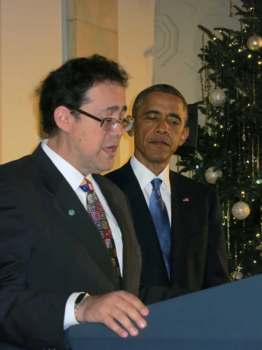 Rabbi Brad Artson, joined by then-President Obama, leads blessings during a 2014 White House Chanukah party. Credut: Courtesy of AJU.