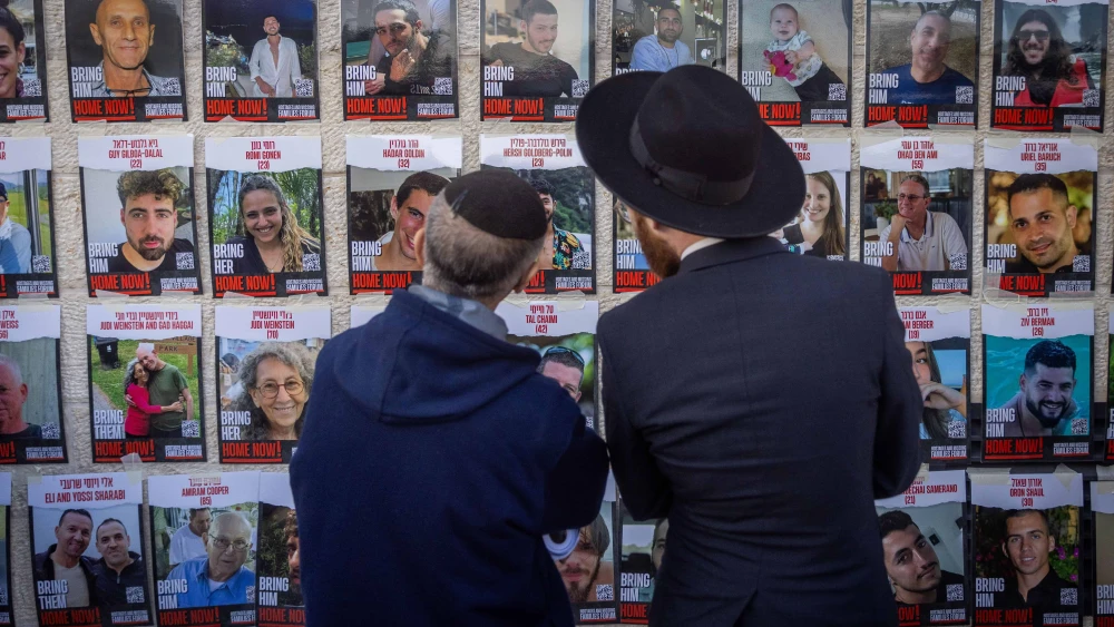 Jews gaze at photos of Israelis held captive by Hamas terrorists in Gaza, at the Western Wall Plaza in Jerusalem, Jan. 10, 2024. Photo by Chaim Goldberg/Flash90.