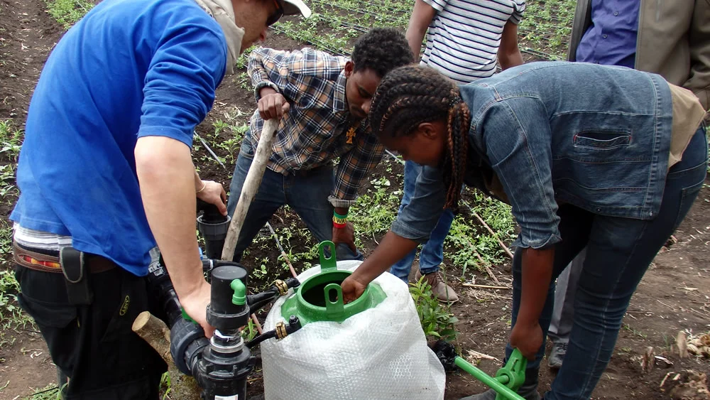 Tikkun Olam Ventures (TOV) team members and local farmers engaging in a learning session of the Israeli drip irrigation equipment. Credit: JDC.