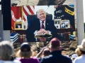 Attendees watch a pre-recorded video of U.S. President Donald Trump reading from the Bible during "Rededicate 250: A National Jubilee of Prayer, Praise and Thanksgiving" on the National Mall in Washington, DC, on May 17, 2026. Photo by Matthew Hatcher / AFP via Getty Images.