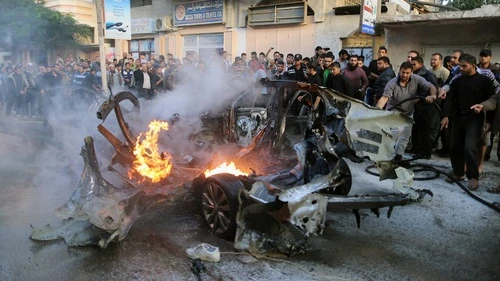 Click photo to download. Caption: People look at a wreckage of the car in which Ahmed Jabari, head of the Hamas's military wing, was killed by an Israeli air strike in Gaza City on Nov. 14. Credit: Wissam Nassar/FLASH90.