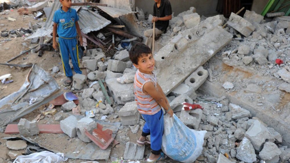 Palestinian youths search through rubble in the Gaza Strip in August 2014, during that summer's war between Israel and the Gaza-ruling Hamas terror group. Credit: UN Photo/Shareef Sarhan.