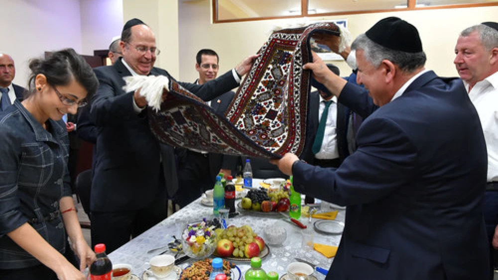 Israeli Minister of Defense Moshe Ya'alon (pictured at left, in center, holding rug) meets with representatives from the Jewish community in Baku, Azerbaijan's capital, on September 10, 2014. Credit: Ariel Hermoni/Ministry of Defense/Flash90.