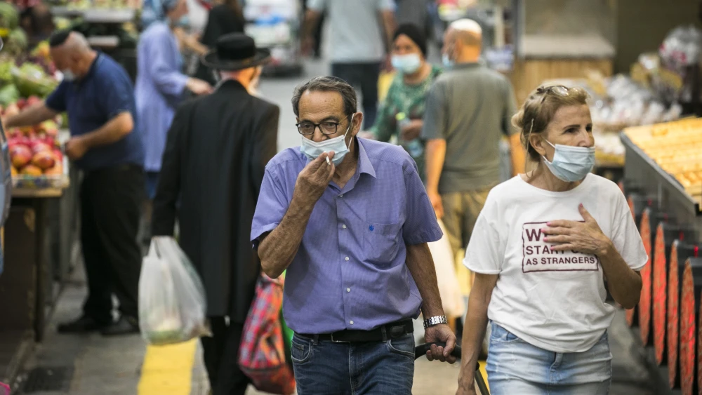 Israelis, wearing face masks for fear of the coronavirus, shop for grocery at the Mahane Yehuda market in Jerusalem on August 20, 2020. Photo by Olivier Fitoussi/Flash90