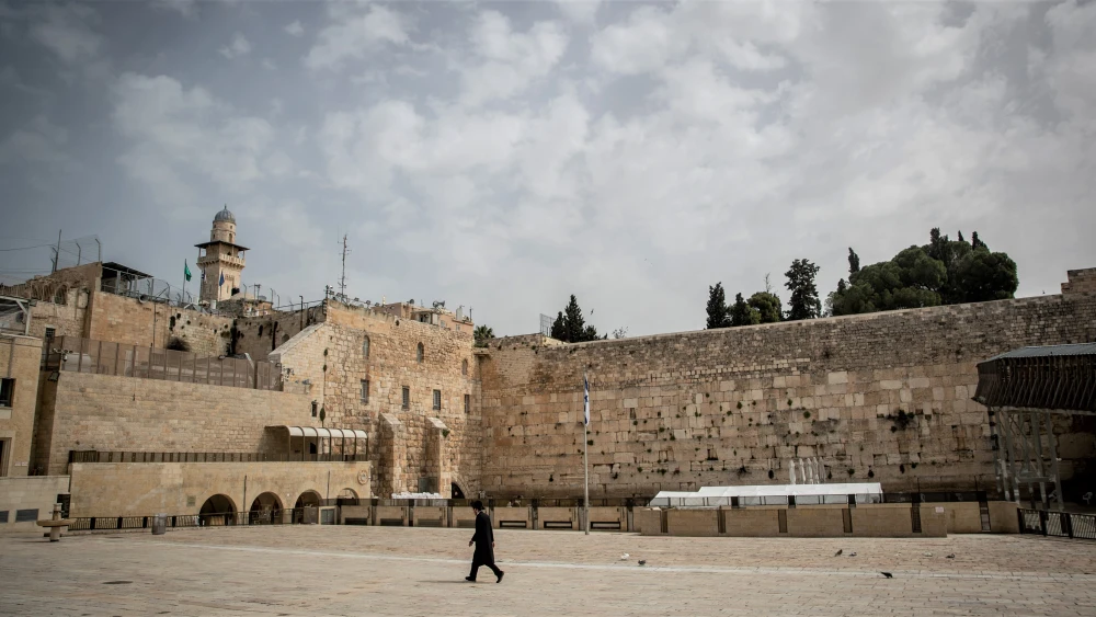 A religious Jew walks near the Western Wall in the Old City of Jerusalem on March 27, 2020. The government ordered a partial lockdown to prevent the spread of the coronavirus (COVID-19). Photo by Yonatan Sindel/Flash90.