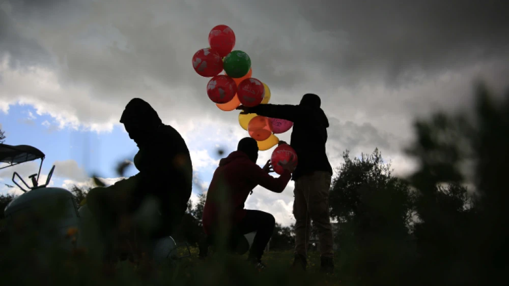 Palestinians prepare an incendiary device to be flown towards Israel, near the Israel-Gaza border in the central Gaza Strip, Feb. 10, 2020. Photo by Ali Ahmed/Flash90.