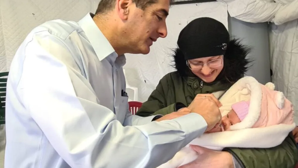 Sheba Medical Center Director Dr. Yitshak Kreiss with a Ukrainian mother and child at the Kochav Meir (Shining Star) Field Hospital in Ukraine. Photo by Naama Frank Azriel.