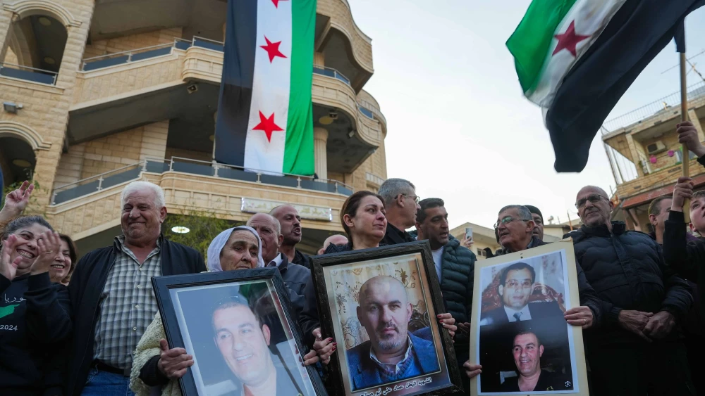 Residents in the Druze village of Majdal Shams hold portraits of people they said were killed by the Assad regime in Syria, during an event in Majdal Shams,Israel, on Dec. 9, 2024. Photo by Ayal Margolin/Flash90.