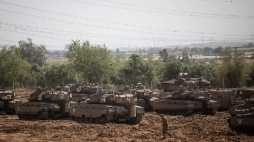 Israeli soldiers seen near IDF tanks stationed near the Israeli Gaza border on May 6, 2019. Credit: Aharon Krohn/Flash90